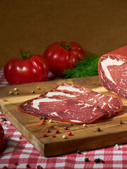 sliced pastrami on a wooden cutting board