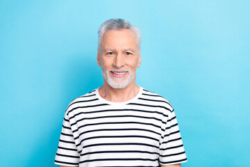 Photo of cheerful charming guy dressed white striped t-shirt smiling isolated blue color background