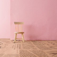 Wooden chair against pastel pink background. Minimal concept composition.