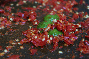 Sambal or traditional chili sauce from Indonesia, freshly made using stone mortar and pestle. Made from red chili pepper and lime.