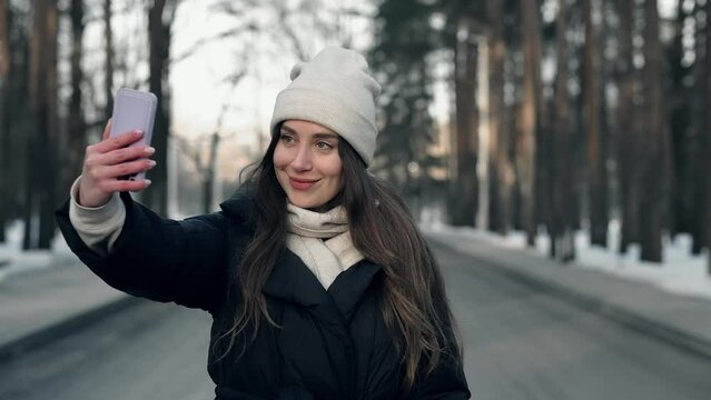 Pretty young girl blogger is taking selfie in winter