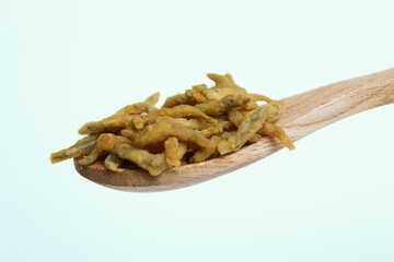 Teri crispy, is whitebait or baby anchovy fish or teri nasi in Indonesia, which fried with flour. In a small wooden spoon. Isolated on white background.