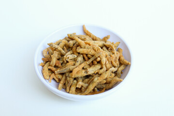 Teri crispy, is whitebait or baby anchovy fish or teri nasi in Indonesia, which fried with flour. In a small white bowl. Isolated on white background.