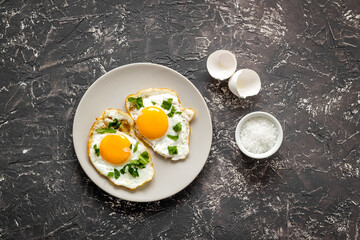 Cooking fried eggs for fast breakfast, top view. Food background