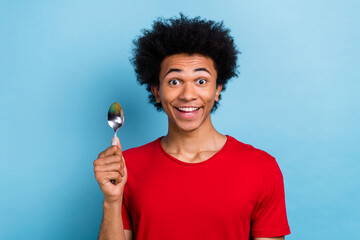 Photo of positive astonished hungry person beaming smile arm hold spoon isolated on blue color background