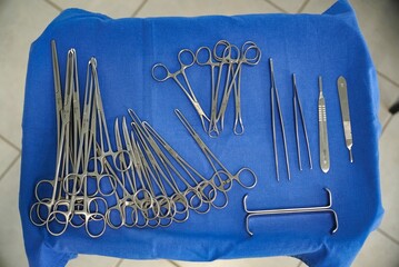 several surgical instruments on a blue table that is laying flat
