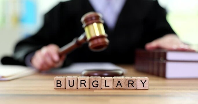 Word burglary made of cubes judge writing down verdict. Theft and robbery are criminal offenses
