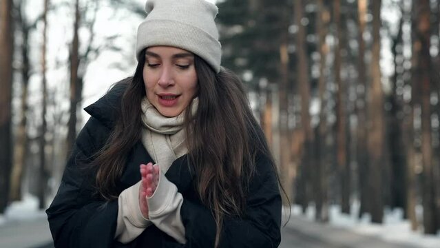 a young pretty girl freezes in a cold winter in a snowy forest