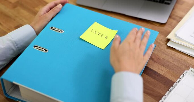 Manager sticks sticker with inscription later on business folder with documents. Reminder important documents