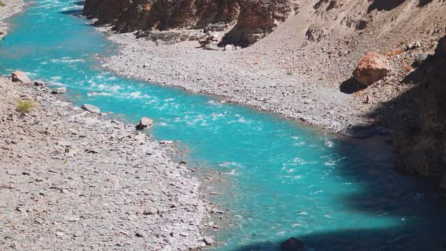 Blue Tsarap chu river flowing in the mountain valley of Zanskar as seen during the trek to Phugtal Monastery from Purne in Zanskar Valley, Ladakh, India. Beautiful blue river flowing in the Himalayas.