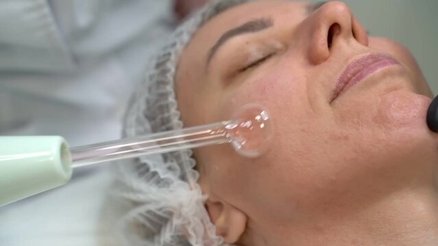 professional skin care video footage. during a facial stimulation procedure with a darsonval device after professional facial skin cleansing Stimulation of regeneration and pro-inflammatory procedure