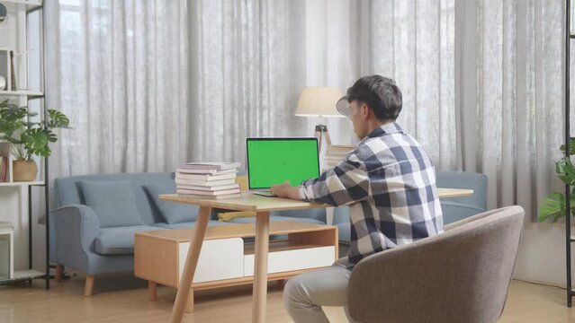 Stressed Asian Teenager Student Having Headache With With Green Mock Up Screen Laptop At Home
