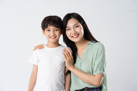 mother and son posing on a white background