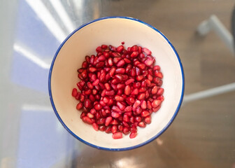 Fresh pomegranate seeds in a white bowl