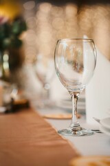 Vertical shot of a wine glass on the table in a restaurant