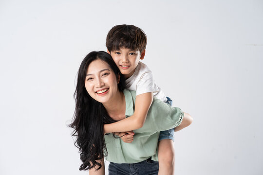 mother and son posing on a white background