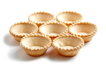 Unfilled tartlet shells isolated on white background. Seven crispy mini tart shells for portable desserts. Unfilled tartlet cups for exquisite taste combinations