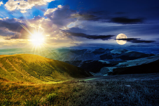 green grass on hillside meadow in high mountains under the cloudy blue sky with sun and moon at twilight. day and night time change concept. mysterious countryside scenery in morning light