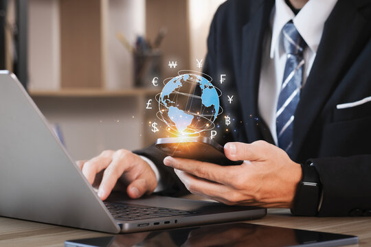 Bussinessman use mobile phones and laptop computers for money transfers and currency exchanges between countries of the world. online banking interbank payment concept..