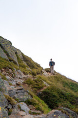 Persona de espaldas andando por sendero en la montaña, cortando con el horizonte