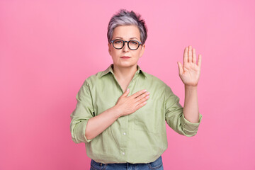 Photo of serious confident pensioner patriot grey hair woman hand touch chest heart proud her country isolated on pink color background