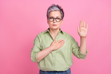 Photo of serious confident pensioner patriot grey hair woman hand touch chest heart proud her...