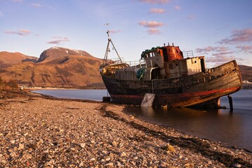 Large abandoned shipwreck on the shore of Loch Linnhe in Scotland at sunset