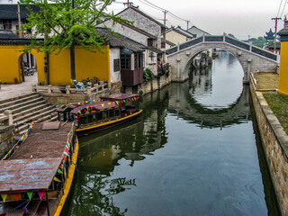 Fototapeta na wymiar Footbridge arch stone bridge to allow boat traffic in the channel underneath, Tongli Water Village, Suzhou, China