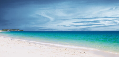 Fototapeta premium Seaside on a cloudy day White sandy beach Clear blue water 3d illustration