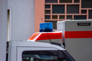 A German ambulance on an emergency call, drives through the streets with flashing lights and...