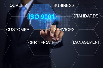 Businessman pointing to the ISO 9001 quality assurance mark to show that the management system in global business has been certified by the auditor or certified body. Quality control and assurance. - obrazy, fototapety, plakaty