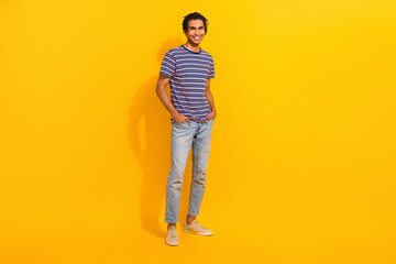 Fototapeta na wymiar Full length portrait of positive confident person put hands pockets posing empty space ad isolated on yellow color background