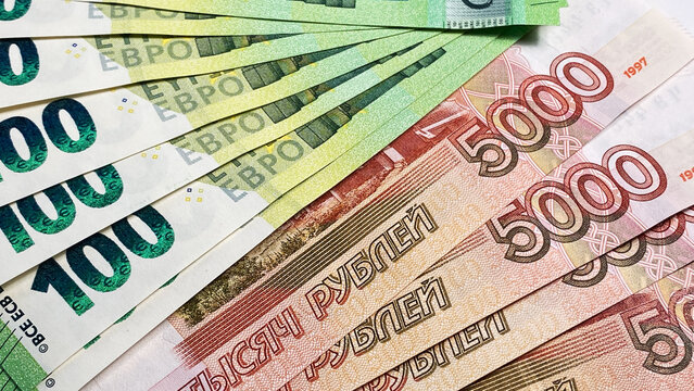 Currency exchange. Several banknotes of 100 euros and 5000 Russian rubles. Banknotes of one hundred euros and five thousand rubles. Economics and finance.