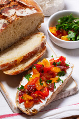 Bruschetta from homemade bread with cottage cheese and sprat pate and tomatoes on a wooden background. Rustic style.