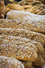 Freshly wholegrain baguette with grains on stall or in grocery shop