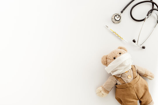 Stethoscope and teddy bear toy in medical mask. Kids health and childcare concept
