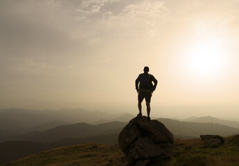 Obraz premium silhouette of a man on a rock at sunset