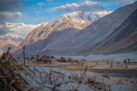 Low-angle landscape image of Himalayan mountain in Hunder, Nubra Valley, Ladakh, India. Wallpaper concept, landscape image of Desert and mountains during sunset.