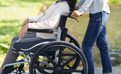 Obraz na płótnie Canvas Nursing home. Young caregiver helping senior woman in wheelchair.