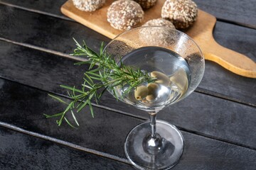 Crystal glass filled with alcoholic drink with olives