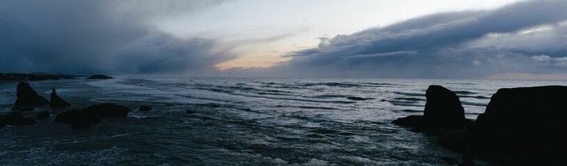 Fototapeta premium Moody sunset photo of the ocean from the Pacific Coast Highway with rich blue and purple colors.