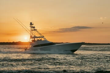 Large fishing vessel is seen navigating through the choppy waters of the open ocean at sunset