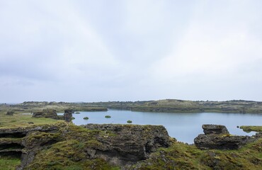 Body of water surrounded by rocks and grass, Lake Myvatn, in the north of Iceland