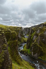 Fototapeta na wymiar Fjadrargljufur valley near some mountains with moss growing on them in Iceland