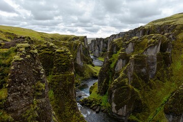 Fototapeta na wymiar Fjadrargljufur valley near some mountains with moss growing on them in Iceland
