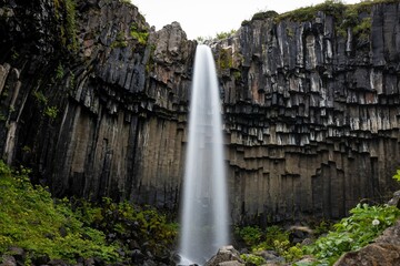 Idyllic landscape featuring a majestic black waterfall Svartifoss cascading down, Iceland