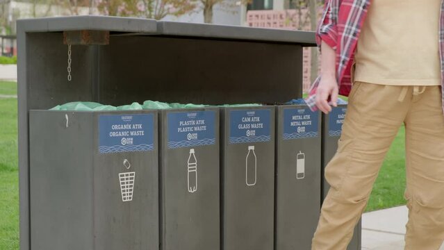 Man throws plastic bottle into trash bin