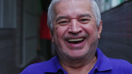 Happy senior man laughing and smiling, portrait face close-up of unshaven mature elderly person in 70s