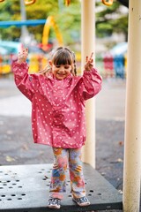 little child is playing in the playground in varna bulgaria, rainy day model shooting 