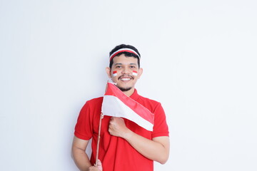 Indonesian man clenched fist, carrying red and white flag, showing excitement when celebrating independence day